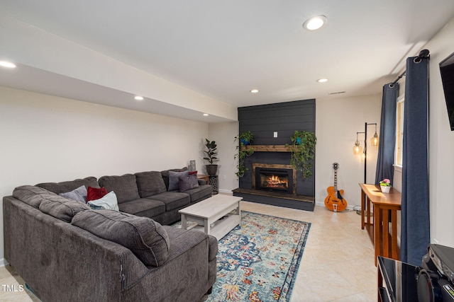living room with baseboards, a warm lit fireplace, and recessed lighting