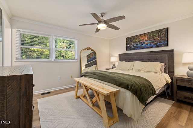 bedroom featuring baseboards, ornamental molding, and wood finished floors
