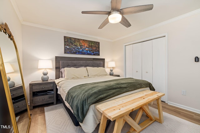 bedroom with crown molding, a closet, ceiling fan, light wood finished floors, and baseboards