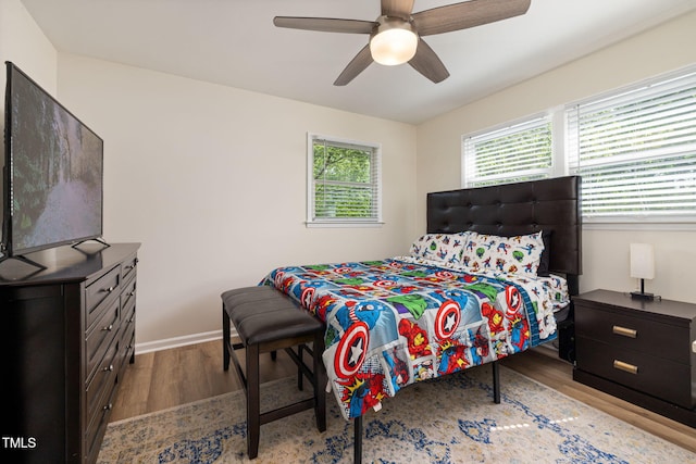 bedroom featuring baseboards, a ceiling fan, and wood finished floors
