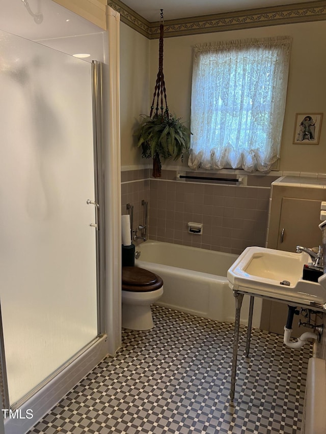 full bathroom featuring a garden tub, toilet, tile patterned floors, and a stall shower