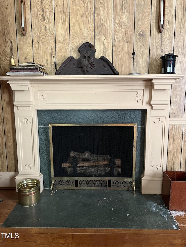room details with a fireplace with flush hearth and wooden walls