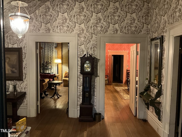 corridor featuring wallpapered walls and dark wood-style floors