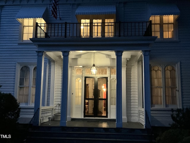 doorway to property with a porch and a balcony