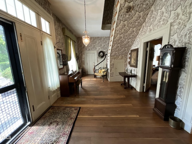 foyer entrance featuring wallpapered walls, hardwood / wood-style flooring, and stairway