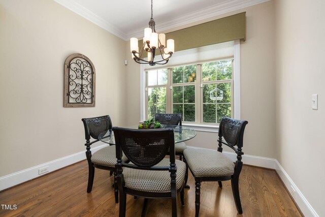 dining area with a chandelier, ornamental molding, baseboards, and wood finished floors