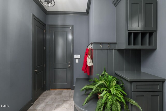 mudroom with ornamental molding and light stone finish flooring