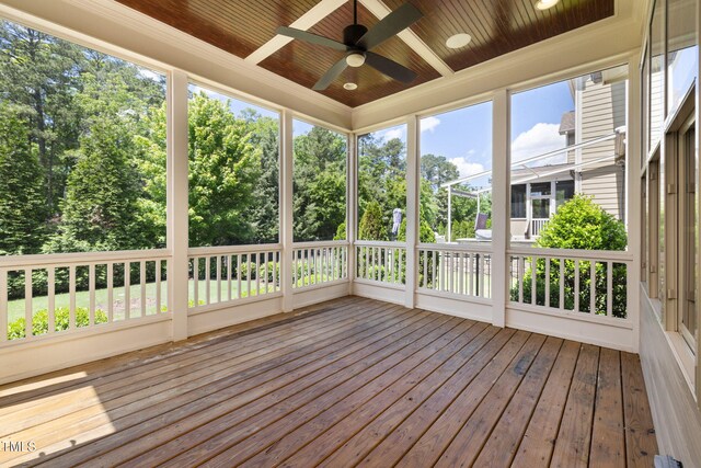 unfurnished sunroom with wooden ceiling, a ceiling fan, hardwood / wood-style flooring, and a deck