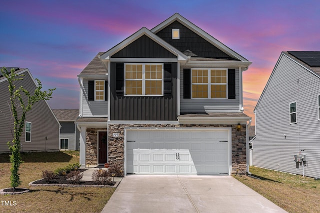craftsman-style house featuring a garage, board and batten siding, driveway, and stone siding
