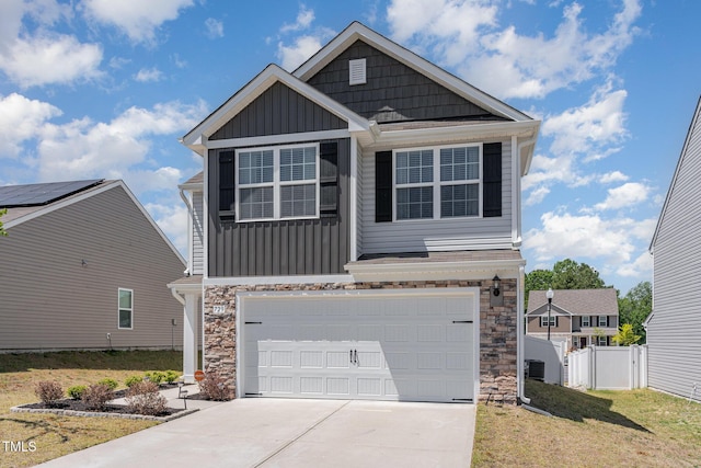 craftsman inspired home with board and batten siding, an attached garage, driveway, and stone siding