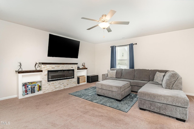carpeted living area with ceiling fan, a glass covered fireplace, and baseboards