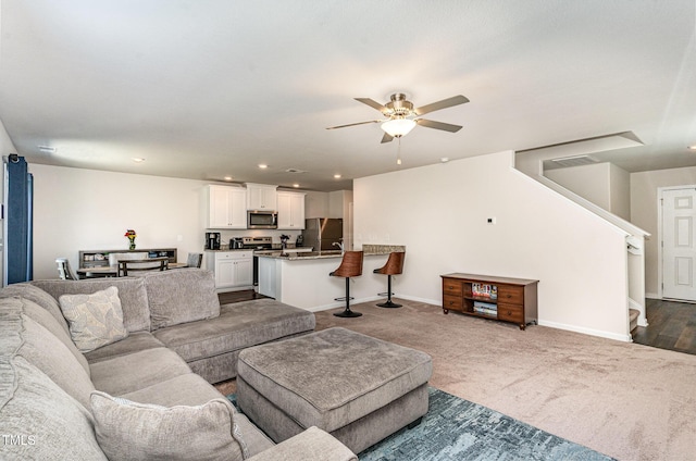 living room with ceiling fan, dark colored carpet, recessed lighting, baseboards, and stairway