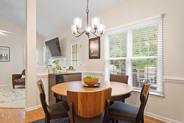 dining area with ceiling fan with notable chandelier, lofted ceiling, and wood finished floors