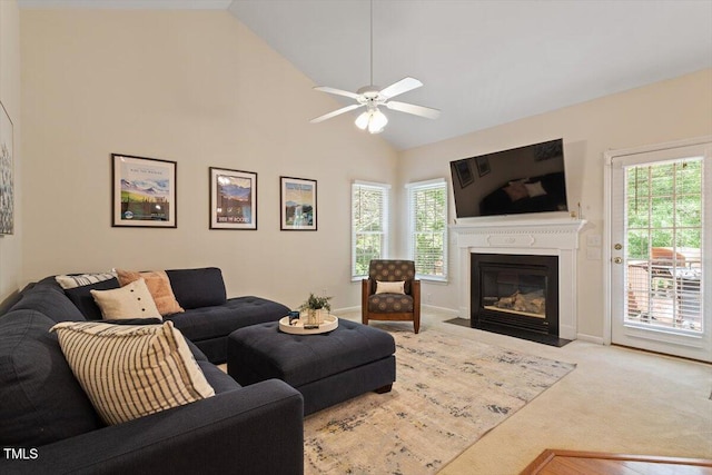 carpeted living room featuring a ceiling fan, high vaulted ceiling, and a fireplace with flush hearth