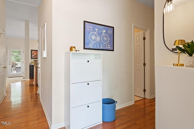 hallway featuring baseboards and light wood finished floors