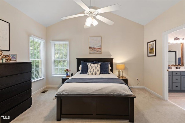 bedroom featuring light colored carpet, a sink, baseboards, and vaulted ceiling