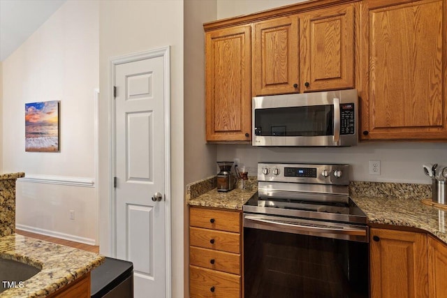 kitchen with light stone counters, brown cabinets, and stainless steel appliances