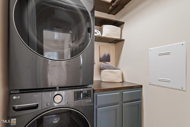 laundry room featuring cabinet space and stacked washing maching and dryer