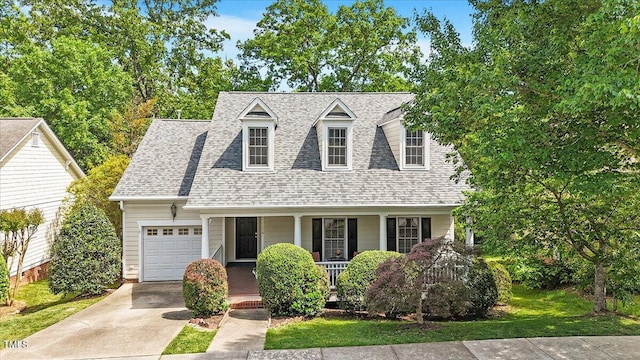 cape cod house featuring a garage, roof with shingles, covered porch, and driveway