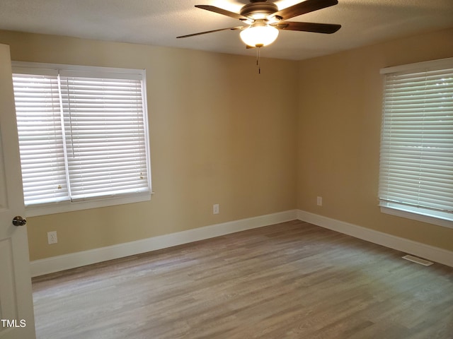 725 Van Thomas Dr, Raleigh, NC 27615 - unfurnished room with wood finished floors, a ceiling fan, baseboards, and a textured ceiling