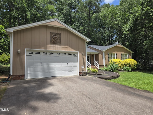 725 Van Thomas Dr, Raleigh, NC 27615 - single story home featuring asphalt driveway, a garage, view of wooded area, and a front yard