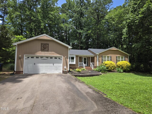 725 Van Thomas Dr, Raleigh, NC 27615 - view of front facade with asphalt driveway, a front lawn, a garage, and covered porch