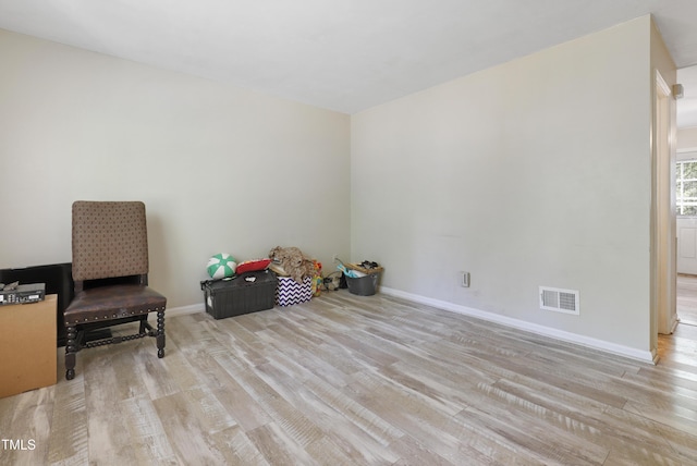 empty room featuring baseboards, wood finished floors, and visible vents