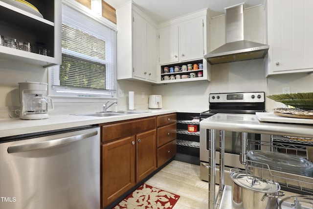 kitchen featuring open shelves, white cabinetry, a sink, stainless steel appliances, and wall chimney exhaust hood