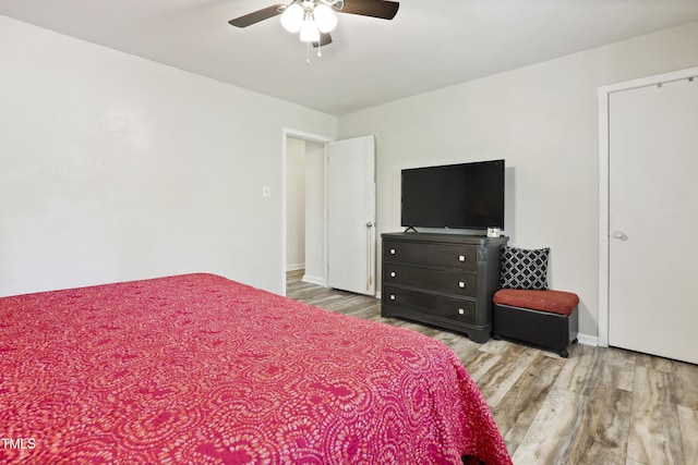 bedroom with a ceiling fan, baseboards, and wood finished floors