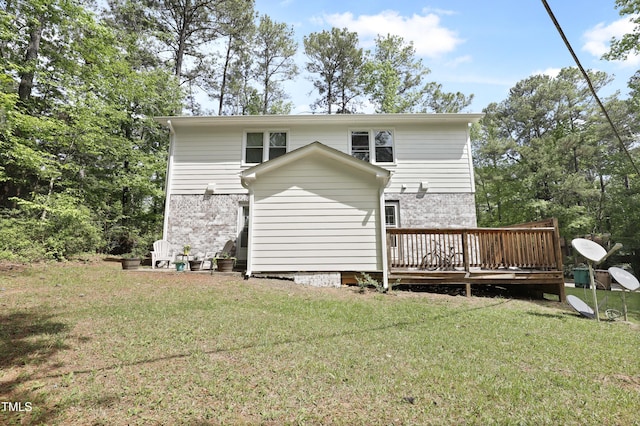 back of house with a yard, brick siding, and a deck