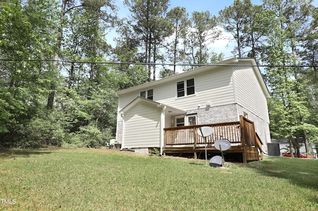 rear view of house featuring a wooden deck, a yard, and cooling unit