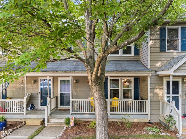 view of front of house featuring covered porch and a shingled roof