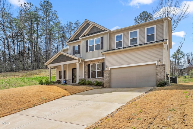 craftsman house with covered porch, brick siding, a garage, and central AC