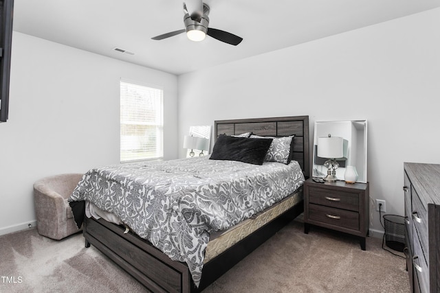 carpeted bedroom with baseboards, visible vents, and a ceiling fan