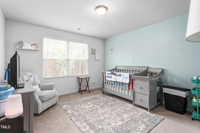 carpeted bedroom featuring visible vents, a nursery area, and baseboards