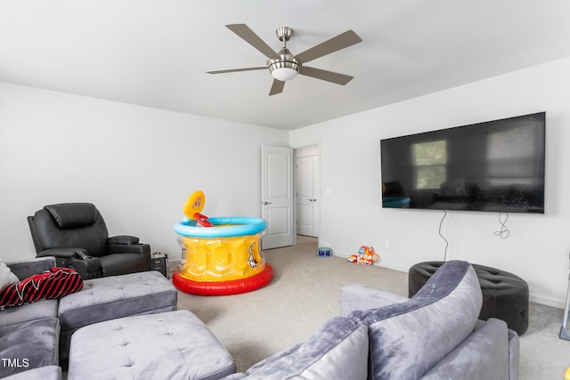 living room with carpet, a ceiling fan, and baseboards