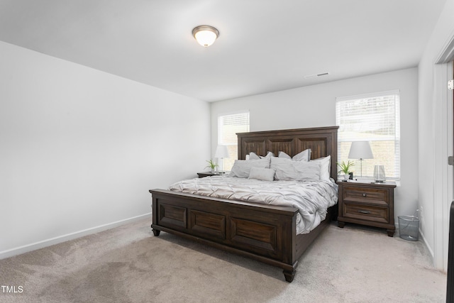 bedroom with baseboards, visible vents, and light carpet