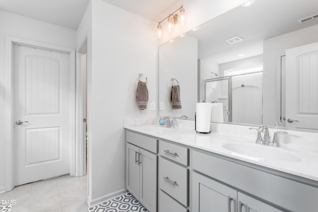 bathroom with visible vents, a shower stall, double vanity, and a sink