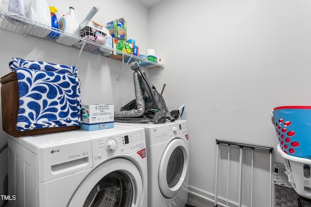 clothes washing area featuring baseboards, laundry area, and washing machine and dryer