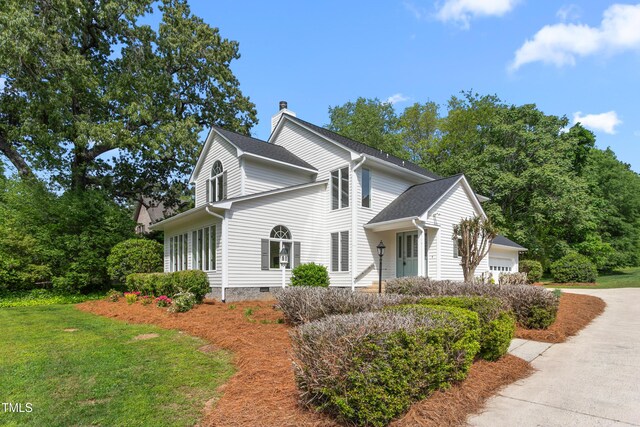 1925 W Lake Dr, Burlington, NC 27215 - view of side of home with a chimney, concrete driveway, a yard, and an attached garage