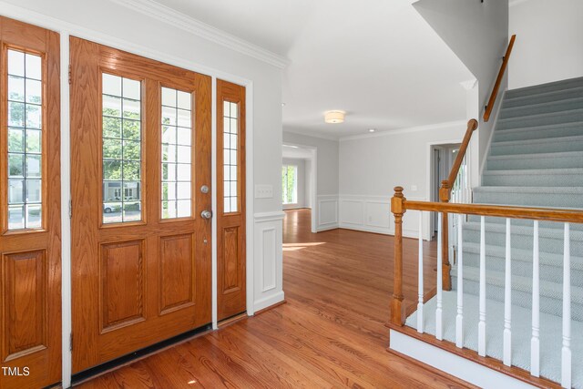 1925 W Lake Dr, Burlington, NC 27215 - entryway featuring crown molding, a decorative wall, wood finished floors, wainscoting, and stairs