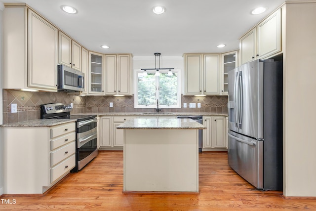 1925 W Lake Dr, Burlington, NC 27215 - kitchen featuring a center island, stainless steel appliances, glass insert cabinets, and a sink