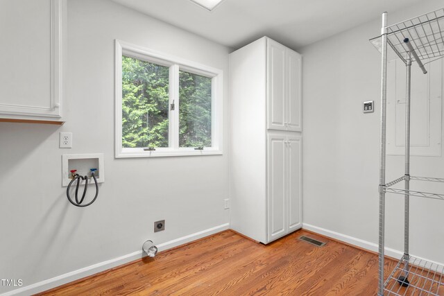 1925 W Lake Dr, Burlington, NC 27215 - laundry area with hookup for an electric dryer, visible vents, hookup for a washing machine, light wood finished floors, and cabinet space