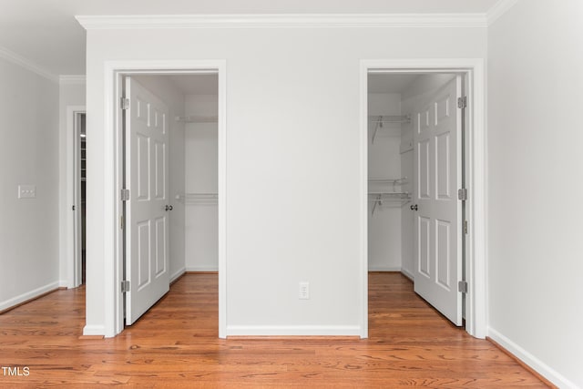 1925 W Lake Dr, Burlington, NC 27215 - unfurnished bedroom featuring light wood-type flooring, a spacious closet, crown molding, and baseboards