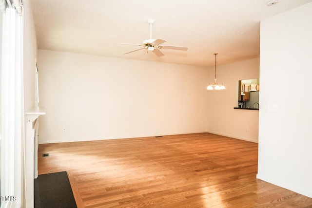 2528 Beech Gap Ct, Raleigh, NC 27603 - unfurnished living room with a ceiling fan, light wood-type flooring, and a chandelier