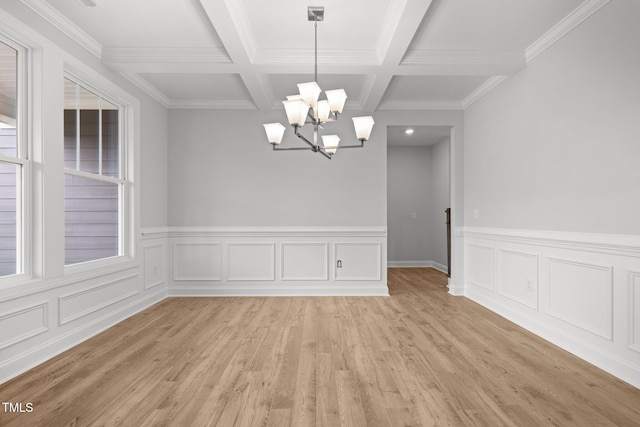 unfurnished dining area with light wood-type flooring, beam ceiling, a chandelier, coffered ceiling, and ornamental molding