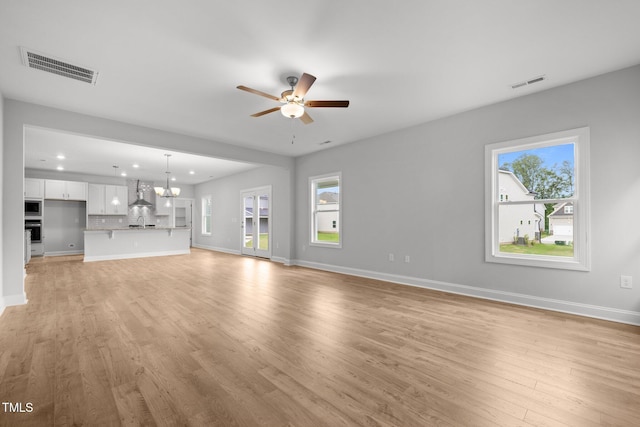 unfurnished living room featuring a ceiling fan, recessed lighting, light wood-style flooring, plenty of natural light, and baseboards