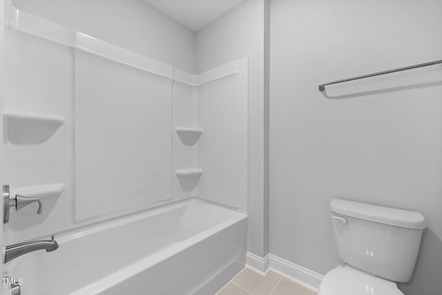 bathroom with tile patterned flooring, toilet, baseboards, and shower / tub combination