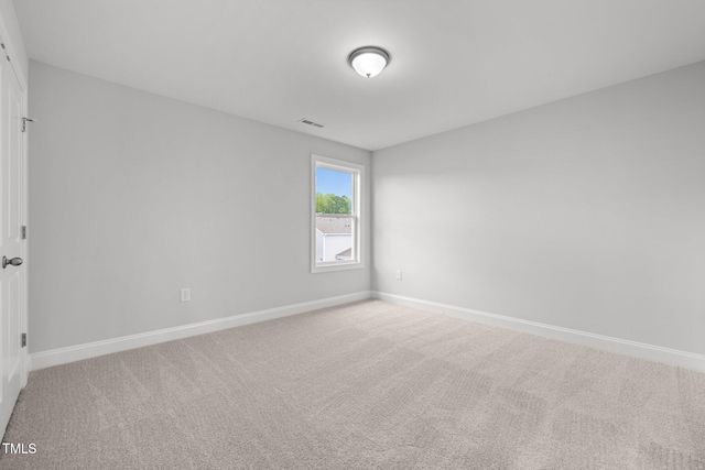 carpeted spare room featuring baseboards