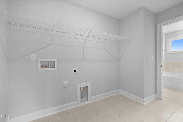 laundry area featuring electric dryer hookup, hookup for a washing machine, gas dryer hookup, and light tile patterned floors
